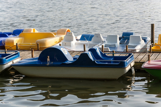 Pedal boats at a wooden pier on a lake