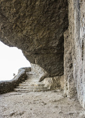 The cliff hanging over the path.