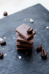 Still Life with chocolate pieces and coffee beans on dark background
