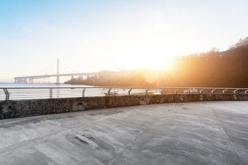 Fototapeta premium empty concrete road with suspension bridge in blue sky