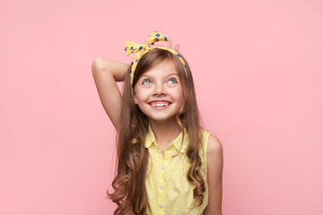 Smiling girl wearing bow looking up