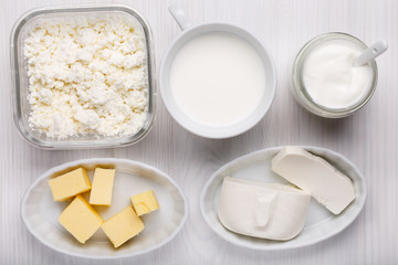 Different type of dairy products on white wooden background.