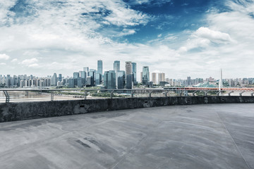 empty concrete road with cityscape of modern city in blue sky