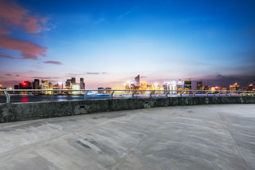 empty concrete road with cityscape of modern city in blue sky