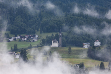 Alpine mountain village on the foggy hills