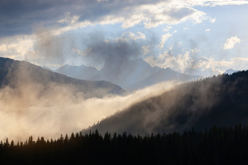 High rocky mountain ridge at cloudy sunset