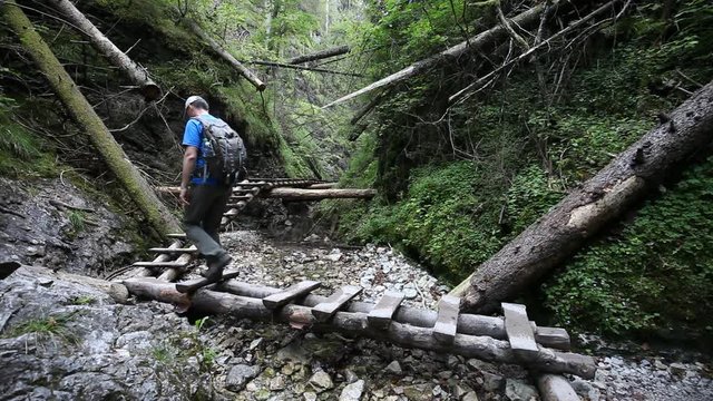 Backpacking hiker man going through rocky canyon