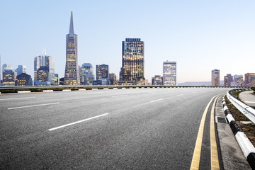 empty road with cityscape of modern city in blue sky