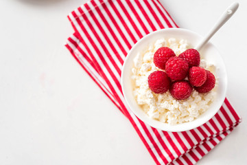 Cottage cheese with raspberry top view on white background, on a kitchen towel. Top view, copy space. Food background