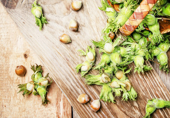 Fresh hazelnuts in shell with leaves, rustic style, vintage wooden background, top view