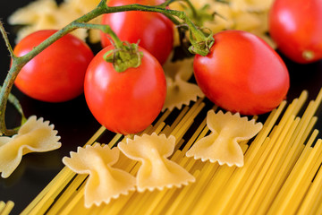 Pasta with cherry tomatoes on a black background