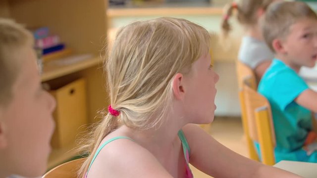 Children are having a singing class and they are singing a song together. 