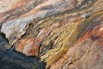Black Sand Basin. Hot springs and bacterial growth have lightened and colored the surface of this barren valley. The flowing river carries this surface away to show the black volcanic sand beneath. 