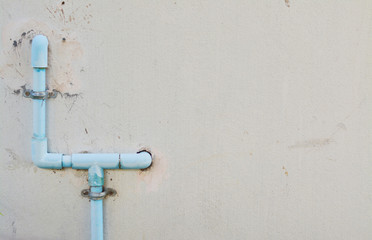 Blue water pipe on cement wall.