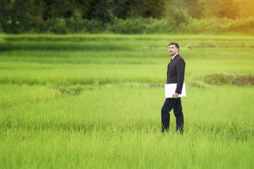 Young researchers - marketers study rice varieties with notebooks. Green meadow