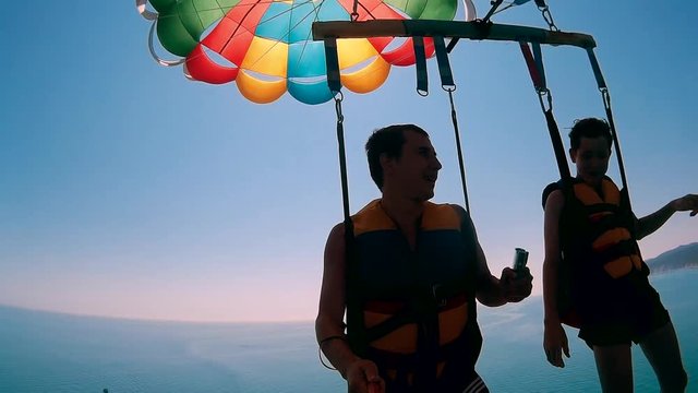 paragliding and parasailing lifestyle. man and boy ocean are flying on a parachute over the sea. Extreme sport first-person view