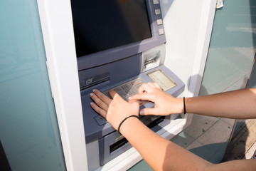 young woman arms at the cash machine