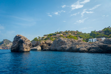 Beautiful view of Mallorca balearic islands, with some buildings in the mountain, in a beautiful blue sky Spain