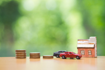 miniature car and house with coins background