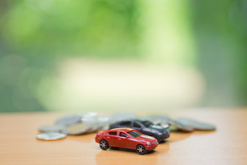 miniature car and house with coins background