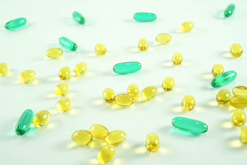 Fish oil capsule, yellow soft gels capsules, Yellow oil pills and blue pill, capsule isolated on white background