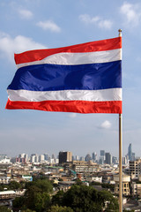 Fototapeta na wymiar Thai national flag waving in the wind on blue background. The flag of the Kingdom of Thailand is flying in the sky.