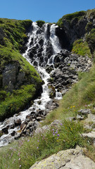 A beautiful waterfall in the mountains in summer