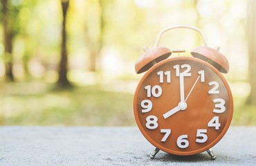 Alarm clock shows eight o clock time in warm morning scene background