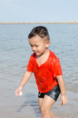 Fototapeta na wymiar Asian boy 4-5 year old having fun and happy on beach
