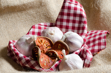  Dried bael tea and Garlic  put on red scott cover by vintage burlap.