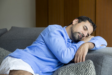 Obraz premium arab man resting on a sofa in his city apartment