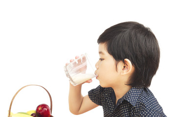 Asian boy is drinking a glass of milk isolated over white background