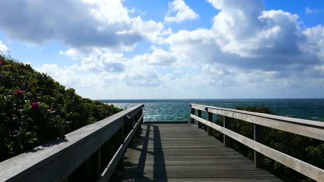 Strandpanorama vom Steg mit Wind, D&uuml;nen, Heckenrosen, Meer und Frau