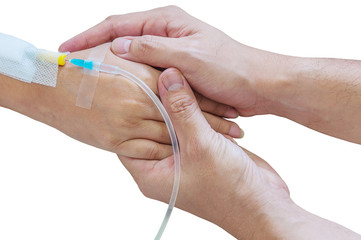 Man holding woman, patient, hand with a tube of medicine injection on a bed in a hospital