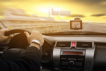 Business man is driving a car using GPS over warm sky yellow background