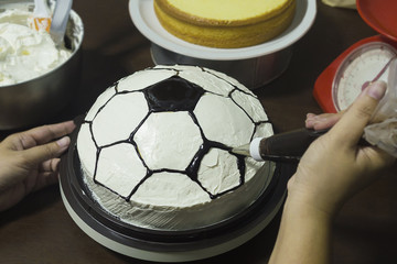 Lady making cake, football pattern decoration © pairhandmade