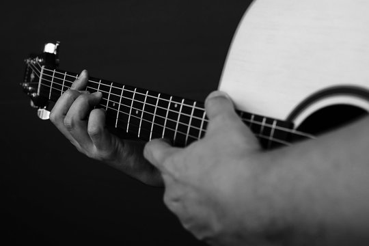 Closeup of man playing guitar in black and white tone