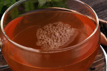 A cup of tea with tea leaves. Tea among the herbs.