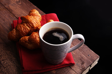 Coffee white cup, croissants on brown wooden background. Breakfast concept