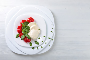 Mozzarella with tomato and green basil.