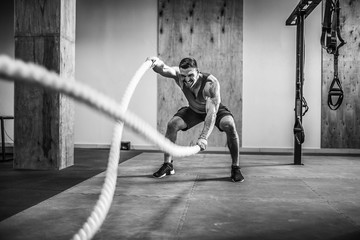 Men with rope in functional training fitness gym
