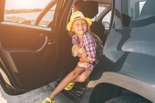Travel, tourism - Girl with teddy bear ready for the travel for summer vacation. Child going on summer vacation. Car travel concept