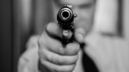 A hired assassin, a terrorist or a policeman in a black mask with a black combat gun