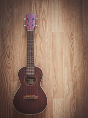 Fototapeta premium Still Life Ukulele on Wooden Floor Background with Copy Space for Background