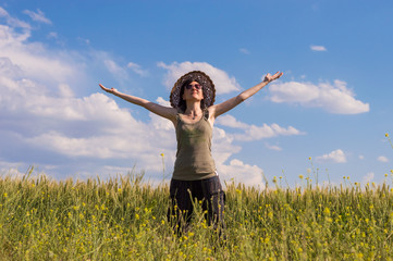 Young woman with hat enjoying the nature. Freedom concept.