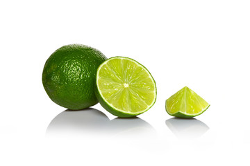Arrangement of whole lime with slices isolated on white background