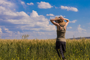 Young woman with hat enjoying the nature. Freedom concept.