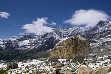 Close up view of a big rock with beautiful mountain landscape in the background. Summer in the Pennine Alps, Valle d\'Aosta, Italy, Europe.