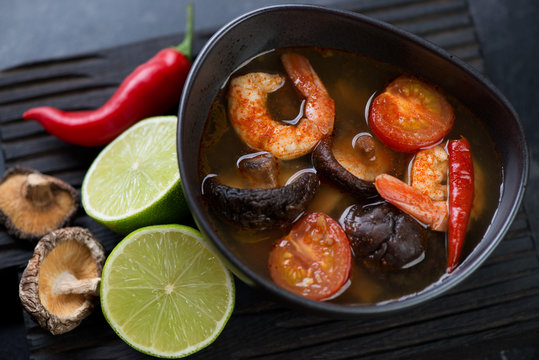 Close-up of spicy Tom Yum Thai soup with shrimps, shiitake mushrooms and red chili peppers, elevated view