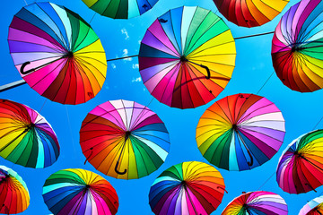 Rainbow umbrella on sky background. Many colorful umbrellas. umbrella street decoration